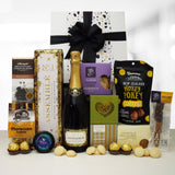 Celebration stash gift basket with champagne, chocolate, shortbread, plum paste and more presented in a modern gift box.